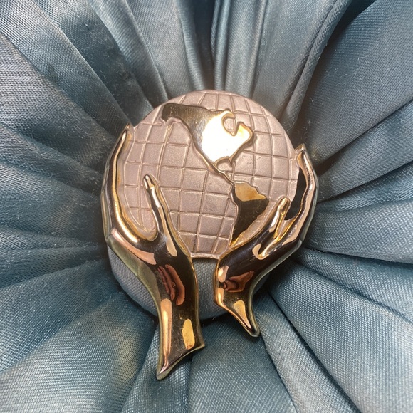 Vintage Jewelry - Vintage hands holding the world brooch